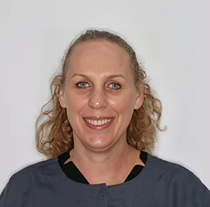 Professional headshot of a smiling woman with curly blonde hair against a white background.