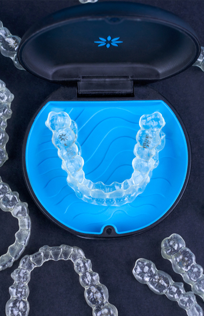 Digital 3D scan of transparent dental aligners arranged in U-shape formation on blue background.