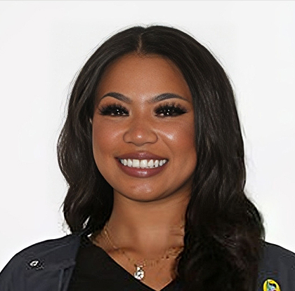Professional headshot of smiling woman in dark shirt against white background, dental practice staff portrait.