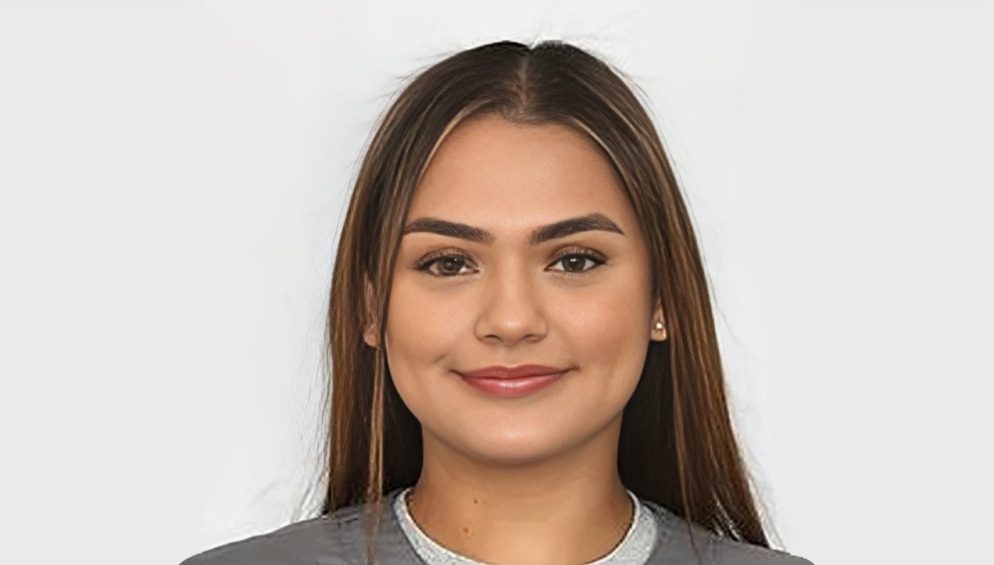 Professional headshot of a young woman with long dark hair wearing a dark jacket against a neutral background.