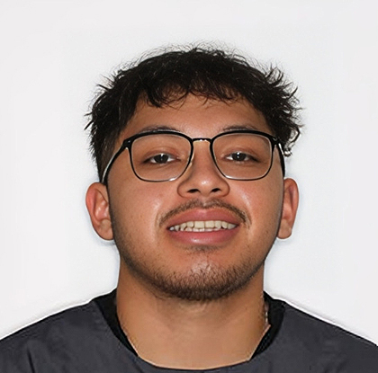 Young man wearing glasses and dark shirt smiling at camera against white background