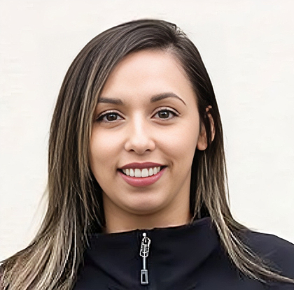 Professional headshot of smiling woman in black jacket against white background.