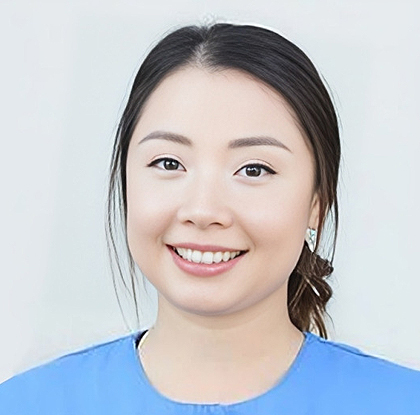 Young woman smiling at camera wearing blue shirt against white background