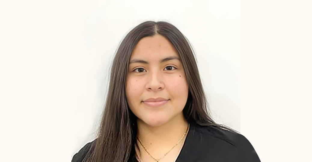Professional headshot of woman with long dark hair against white background, dental office staff photo.