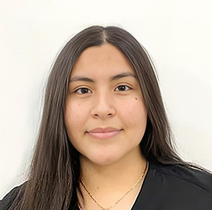 Professional headshot of a woman with long dark hair against a white background, wearing black clothing.