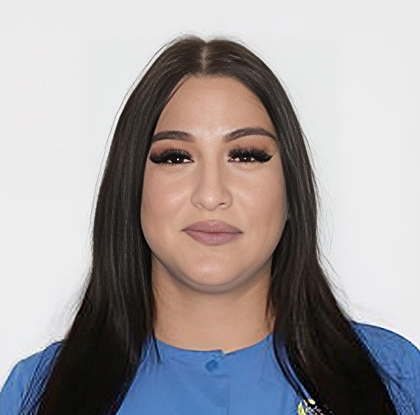 Woman with long dark hair wearing blue shirt against white background, professional headshot.