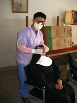 Pediatric dentist examining young patient in dental chair at office