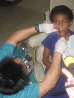 Young patient receiving dental examination with intraoral camera in pediatric dental office.