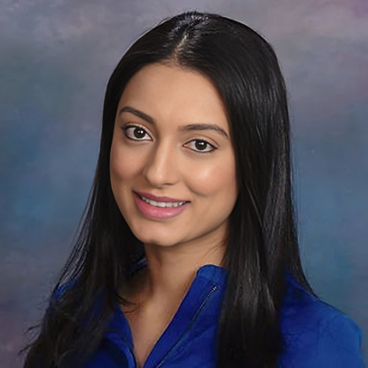 Professional headshot of woman with long black hair wearing blue top against blue gradient background.