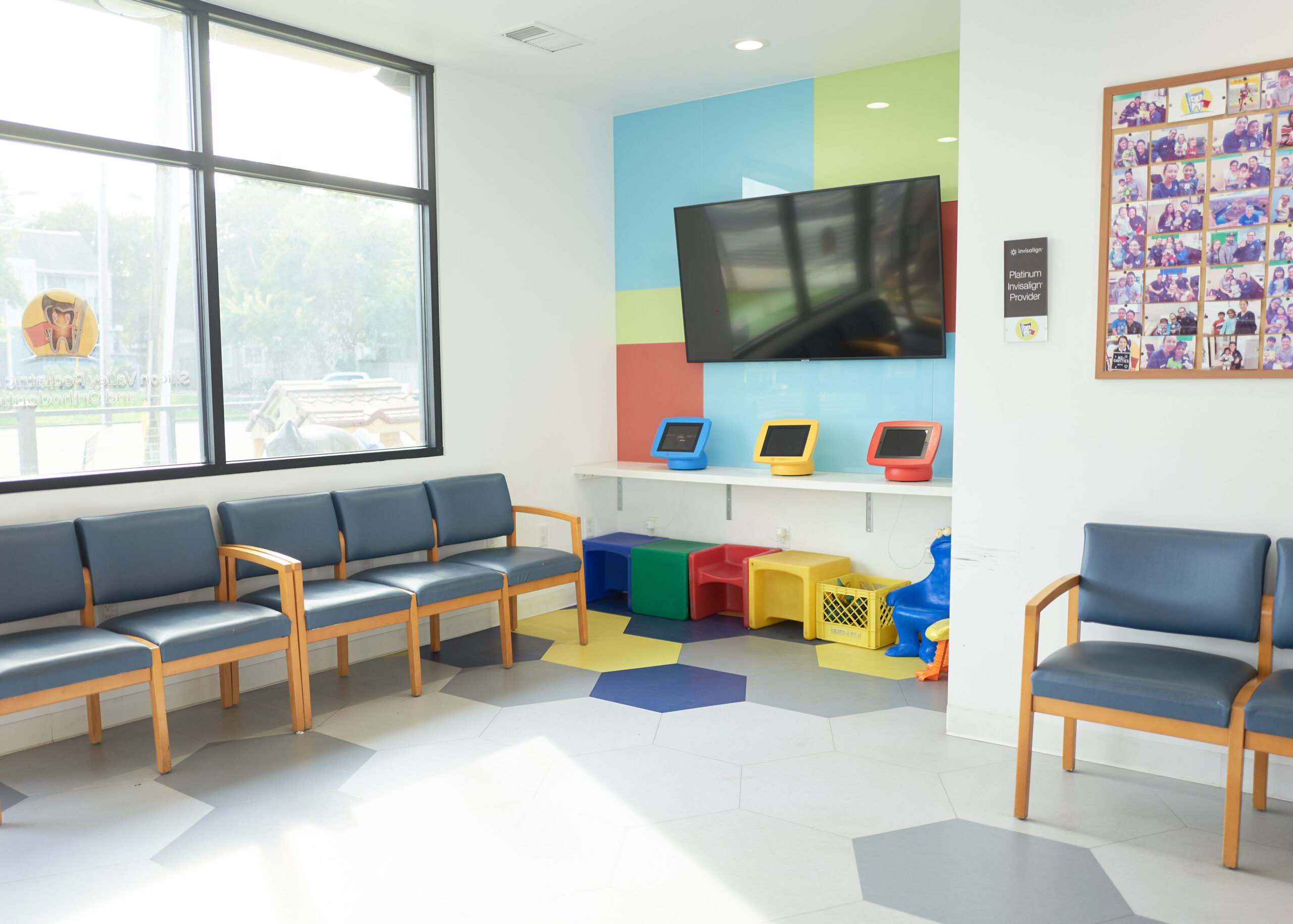Bright, modern pediatric dental office waiting room with colorful storage cubbies and comfortable seating.