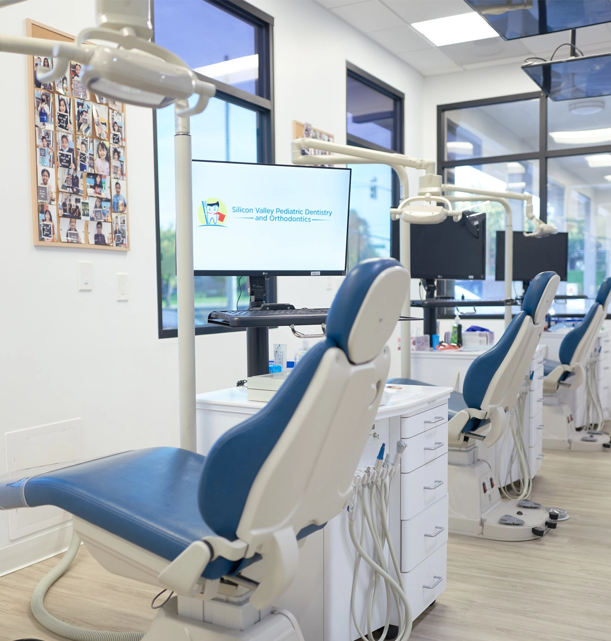 Modern dental treatment chairs in bright, clean pediatric dental office with blue upholstery.