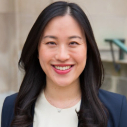 Professional headshot of smiling woman in business attire for dental practice website.