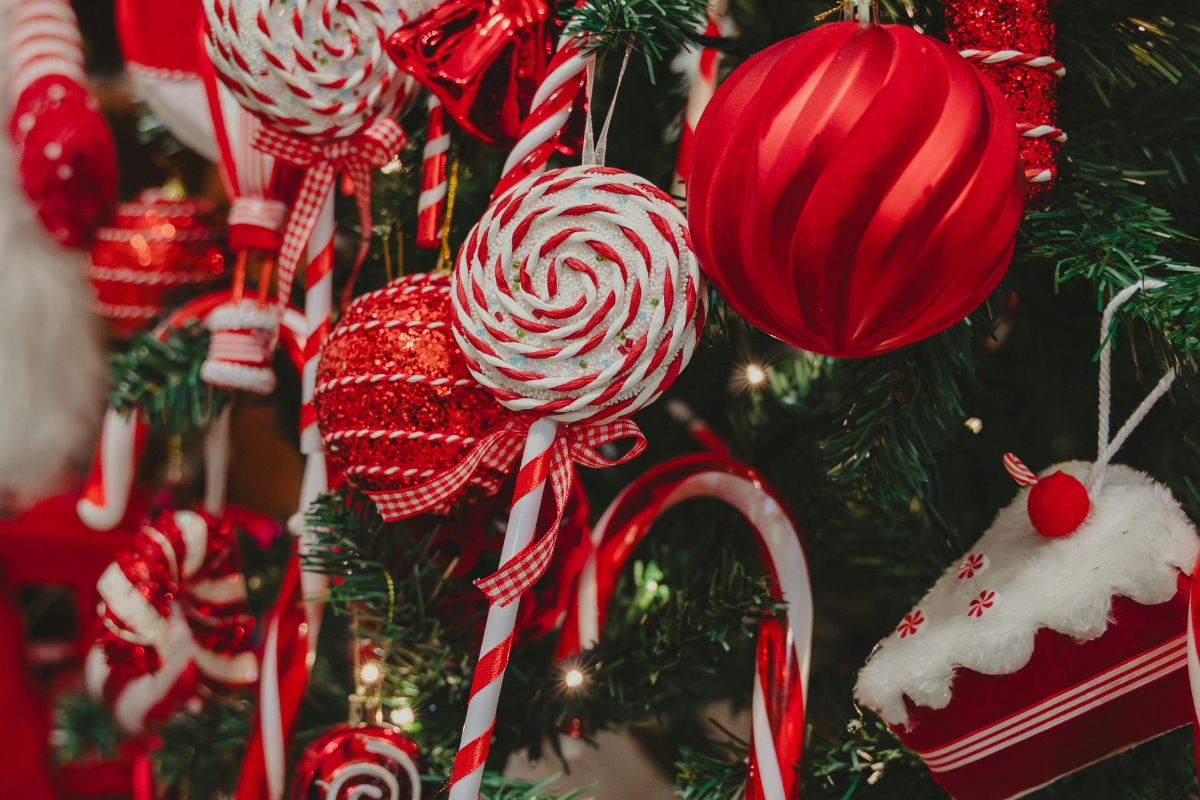 Red and white Christmas ornaments, candy canes, and lollipops decorating a festive holiday tree.