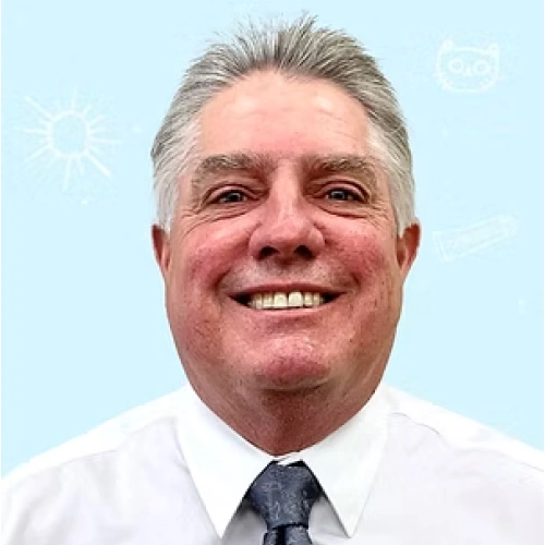 Professional headshot of smiling male dentist in white shirt and tie against light blue background.