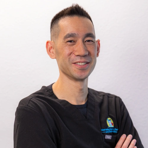 Professional headshot of Dr. Josh Lin smiling with arms crossed, wearing black scrubs against a white background.