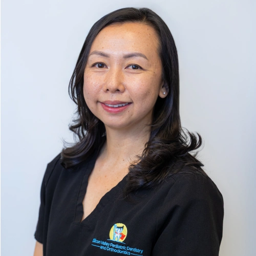 Professional headshot of Dr. Nancy Li smiling with dark shoulder-length hair, wearing black scrubs against a white background.